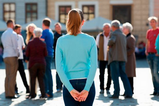 Женщина стоит у толпы Женщина стоит у толпы и боится подойти